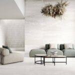 Sofa-and-chair-with-light-tiles-on-floor-and-walls-and-dried-flower-creation-hanging-from-ceiling