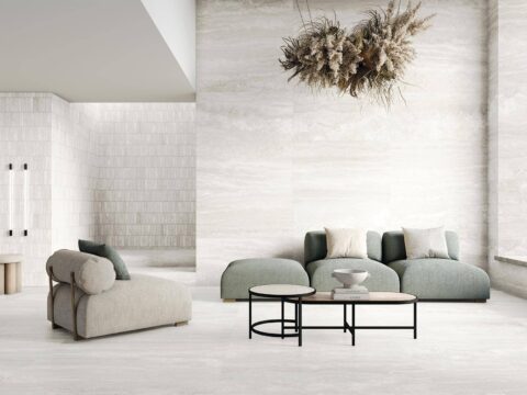 Sofa-and-chair-with-light-tiles-on-floor-and-walls-and-dried-flower-creation-hanging-from-ceiling