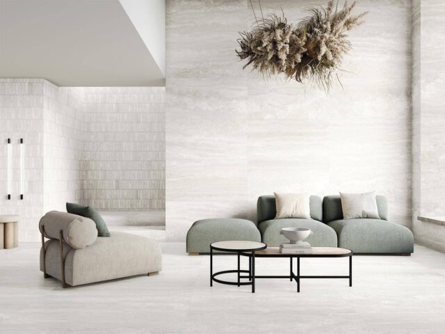 Sofa-and-chair-with-light-tiles-on-floor-and-walls-and-dried-flower-creation-hanging-from-ceiling