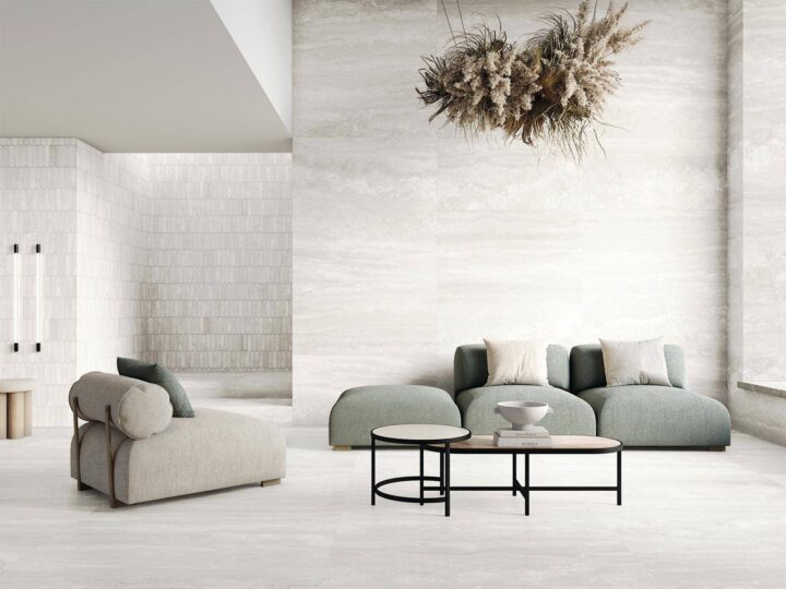 Sofa-and-chair-with-light-tiles-on-floor-and-walls-and-dried-flower-creation-hanging-from-ceiling