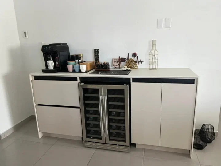 A white-shiny-kitchen-countertop-with-coffee-machine-and-mugs
